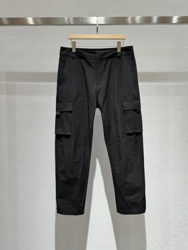 Sq00300-Dior口袋拼接徽章标识男士工装裤休闲裤 这款工装裤采用黑色弹力华达呢精心制作。 实用的版型搭配大号翻盖口袋和踝部按扣， 后侧饰以 Dior 标