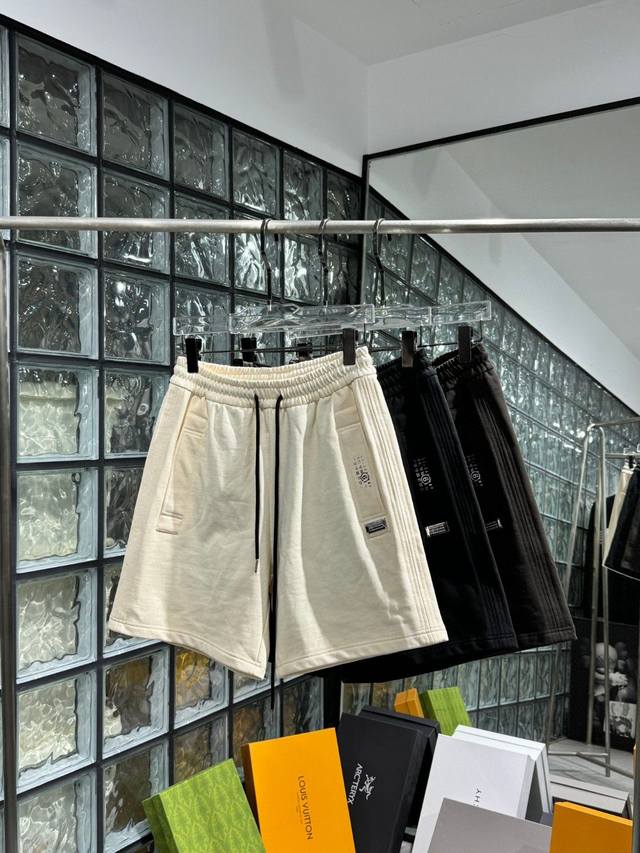 Mm*6 马吉*拉 2024春夏款男士休闲短裤。客供高级定制面料，手感柔和，光泽感极佳，是任何一种面料都无法媲美的。裤腿品牌logo图案设计，视觉效果华丽时髦。