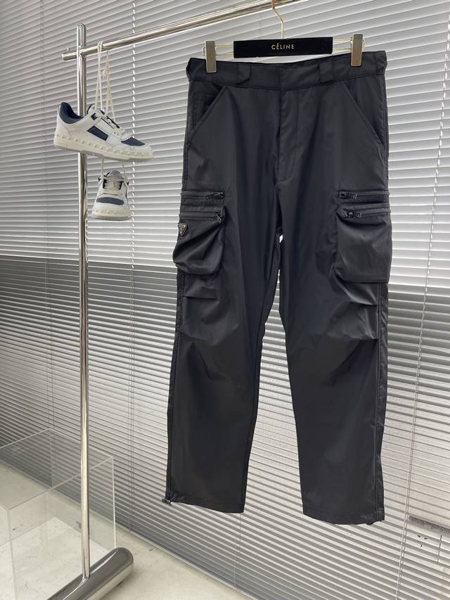 Prad 24Ss 春夏新款工装裤 这款极简夹克面料取材re-Nylon再生尼龙打造，工装裤两侧拉链多口袋设计 凸显时尚。Re- Nylon再生尼龙通过提纯海洋